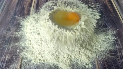 A broken chicken egg falls on a hill of flour. Stock Footage 232219733