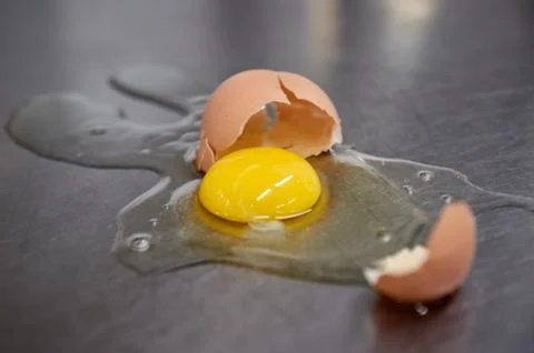 Broken chicken egg on the iron table close-up. horizontal view. a raw egg. Stock Photos