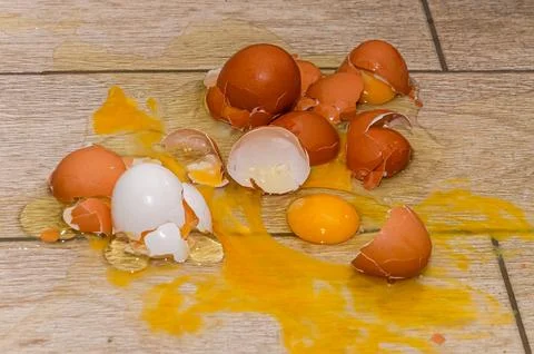 Broken chicken eggs on the kitchen floor Stock Photos