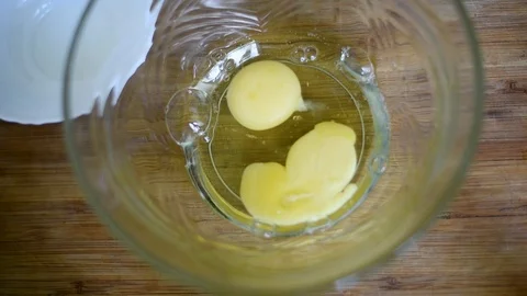 Broken chicken eggs in a transparent container for cooking Stock Footage 95097305