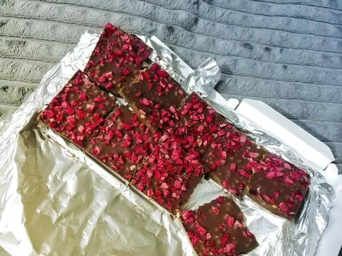 Broken chocolate bar on foil Stock Photos