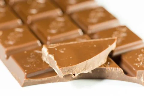 Broken chocolate bar left position isolated on white table. Horizontal compos Stock Photos