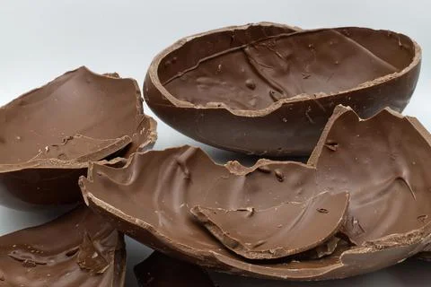 Broken chocolate easter egg in a bowl isolated on white background Stock-Fotos
