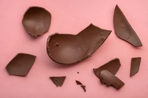 Broken chocolate Easter egg over pink background, holiday concept 스톡 사진