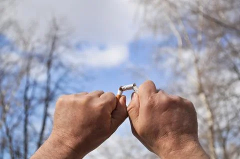 Broken cigarette in his hand Stock Photos