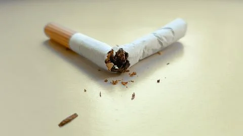 Broken cigarette isolated on a yellow background. View from above Stock Photos