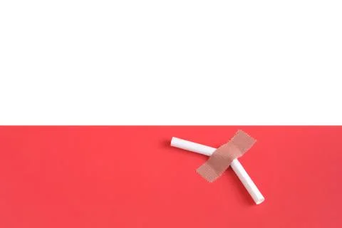 Broken cigarette on a light pink background. Stock Photos