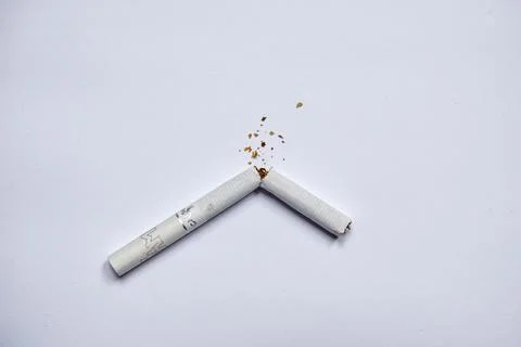 Broken cigarette on a white background. Stock Photos