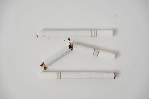 A broken cigarette on a white background Stock Photos