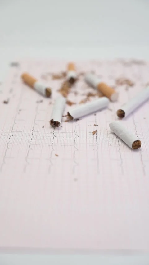 Broken cigarettes lying on an electrocardiogram test report Stock Footage 335191979
