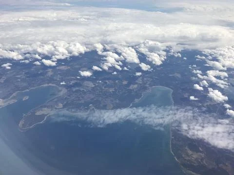 Broken clouds and blue sky seen from an airplane window Stock Photos
