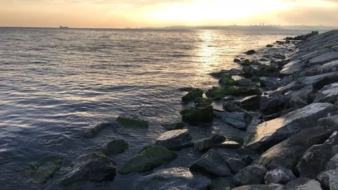 Broken clouds during the sunrise by the sea and rocks. Tilt move contains Video stock 75457326