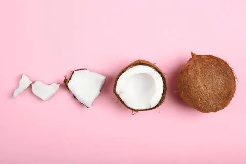 Broken coconut on a colored background. Stockfoto's