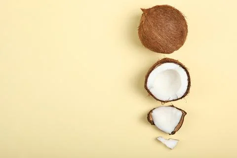 Broken coconut on a colored background. Stockfoto's