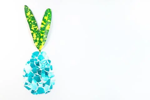 A broken colored eggshell in the shape of an egg on a light background with c Stock Photos
