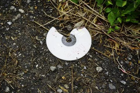 Broken compact disk thrown on the ground Stock Photos