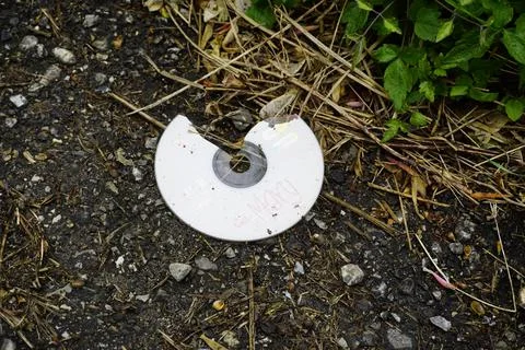 Broken compact disk thrown on the ground Stock Photos