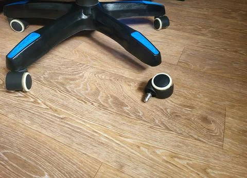 A broken computer chair with one wheel missing Stock Photos