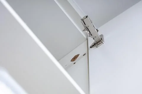 Broken concealed hinge on cabinet door, furniture fitting hardware Stock Photos