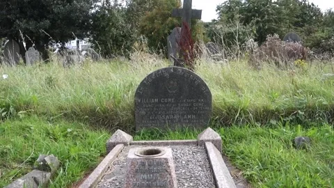 Broken cross on a grave with flowers Stock Footage 138527892