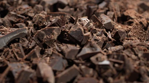 Broken crushed dark chocolate bits on background rotates.  Sweet food Stock Footage 307789246