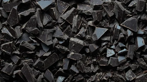 Broken crushed dark chocolate bits on background rotates.  Sweet food 스톡 동영상 320598921