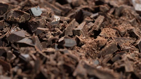 Broken crushed dark chocolate bits on background rotates.  Sweet food 스톡 동영상 331637166