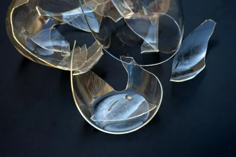 Broken cup on a black background. Mug with double bottom transparent shards Stock Photos