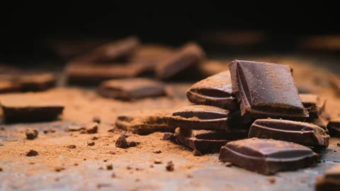 Broken dark chocolate bars on black background, stack of chocolate pieces Stock Footage 148389774