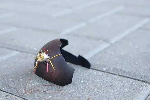 A Broken Decorative Shield Featuring a Gold Spider Resting on the Pavement Below Stock Photos