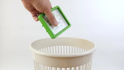 A broken desk clock is thrown into the trash can. Disposal of household waste Stock Footage 274050757
