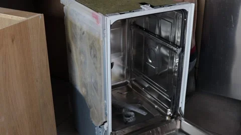 Broken dishwasher partially disassembled during repair, technician examines.. Stock Footage 319825275