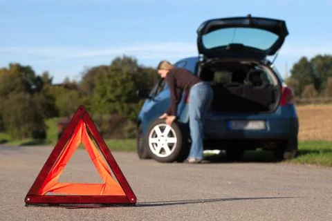 Broken down car with red warning triangle Stock Photos