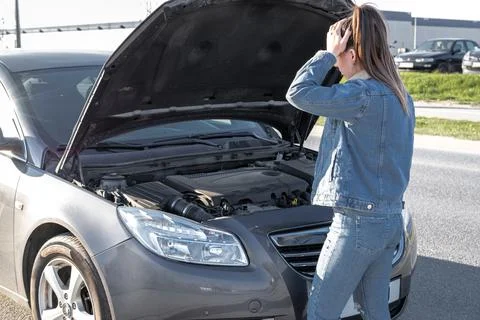 Broken down car. Vehicle engine motor problem concept. Driver girl near open  Stock Photos