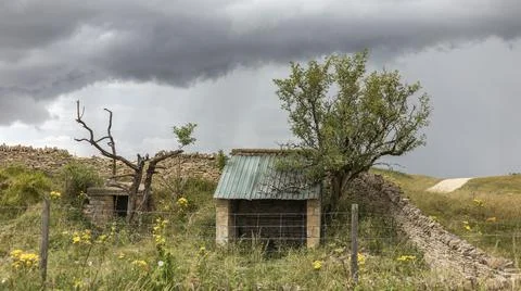 Broken down shepherds hut against a stormy sky Stock Photos