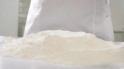 Broken egg falls down on flour heap on table against baker Video stock 137932162