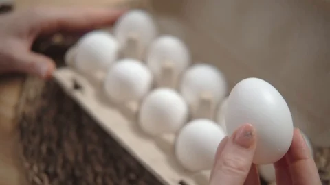 Broken egg in a female hand. Eggshell crack. Close up. Stock Footage 125093484