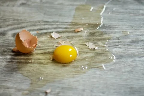 Broken egg on the floor with copy space. Selective focus. This photo can be u Stock Photos