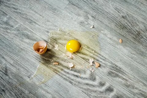Broken egg on the floor with copy space. Selective focus. This photo can be u Stock Photos