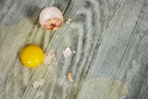 Broken egg on the floor with copy space. Selective focus. This photo can be u Stock Photos