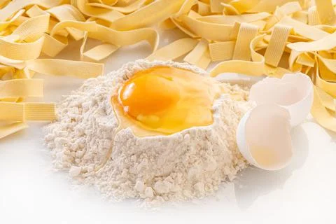 Broken egg in flour and pasta Stock Photos