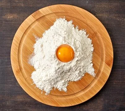 Broken egg in flour on cutting board Stock Photos