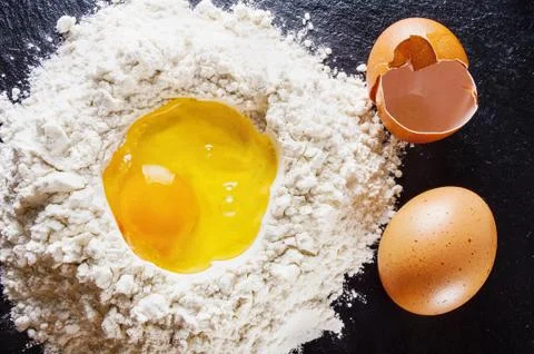 Broken Egg on pile of flour Stock Photos