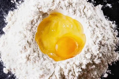 Broken Egg on pile of flour Stock Photos