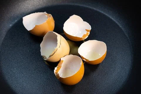 Broken egg shells on the pan. Expensive price on eggs in Russia. Overpriced.. Stock Photos