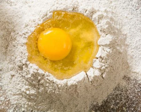 Broken egg on top of a bunch of white rye flour. Preparation of dough or brea Stock-Fotos