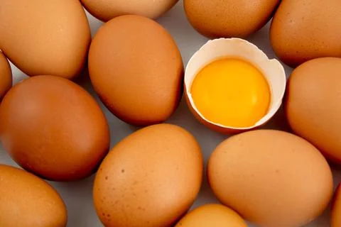 Broken egg with whole brown eggs. Egg yolk. Egg background Stock Photos