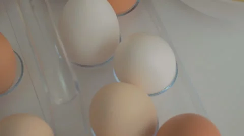 Broken egg with yolk and egg white on white board, with egg shells and whole Stock Footage 43225345