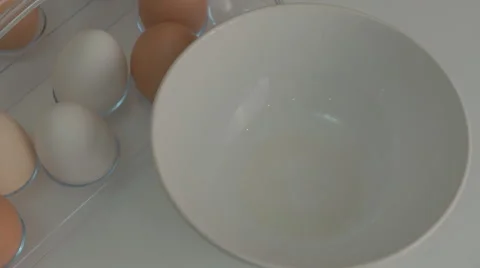 Broken egg with yolk and egg white on white board, with egg shells and whole Stock-Footage 43811067