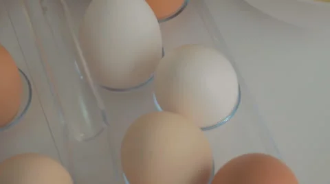 Broken egg with yolk and egg white on white board, with egg shells and whole Stock-Footage 43811157